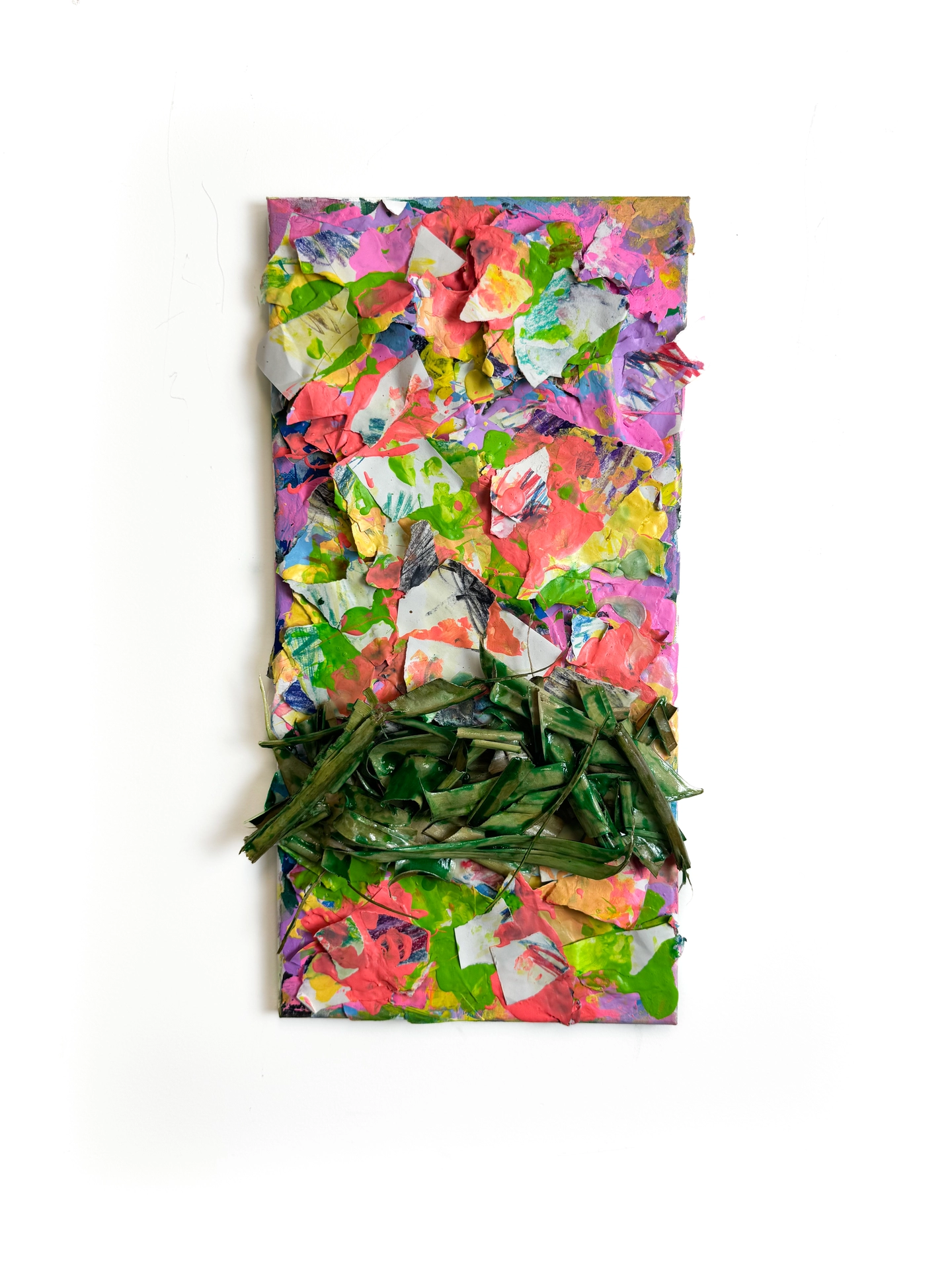 The image depicts a three-dimensional collage created from torn and painted paper in light green, yellow, lilac, pink, and peach colors. Positioned just below the center and across the work are glossy, organic, green-colored strips arranged in tangle-like patterns.