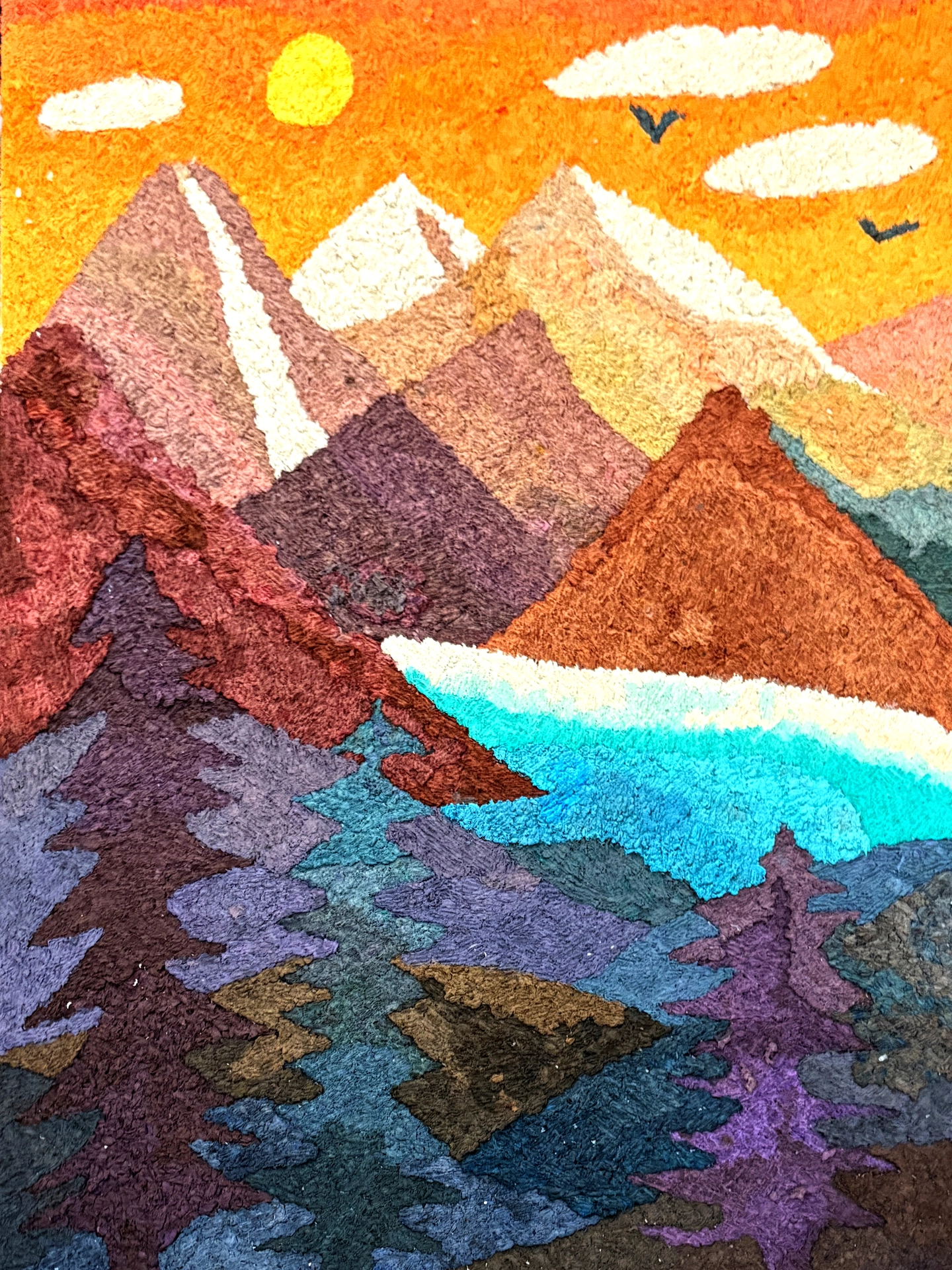 A mountain-scape of various brown peaks with an orange sky, white clouds, and yellow sun. An electric blue lake is hidden behind dark trees in purples and greens that rise in the foreground.