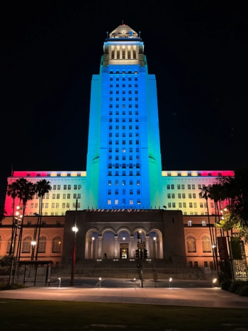 Los Angeles City Hall lit up in red, yellow, green, blue, and white to reflect the colors of the Disability Pride Flag, honoring the 35th anniversary of the Americans with Disabilities Act.